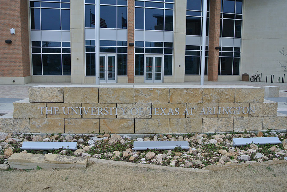 entrance sign to a university with brown stones